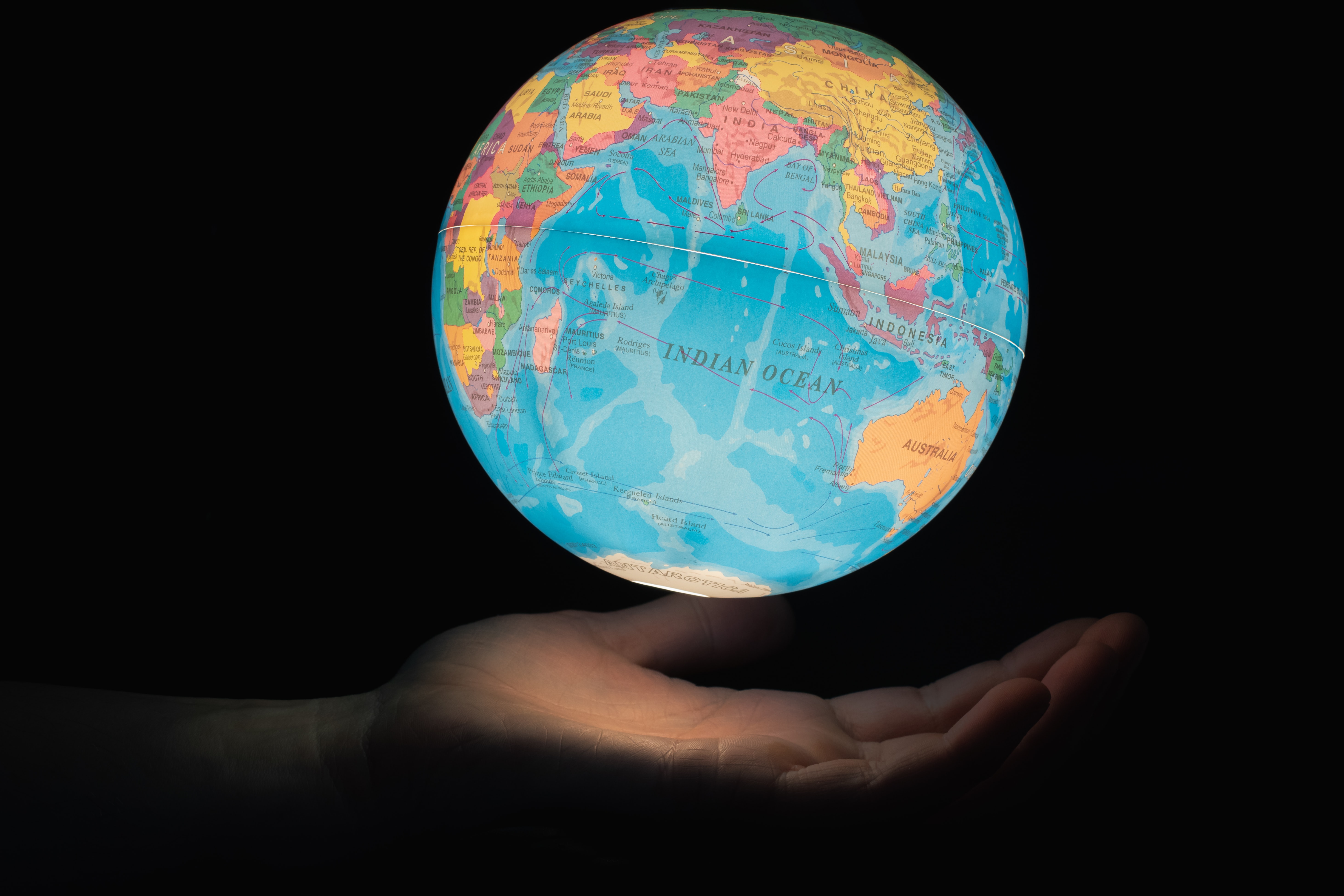 Glowing globe floating above hand
